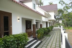 a house with a walkway in front of it at Paradise Riviera in Ernakulam