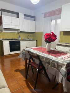 a kitchen with a table with a vase of flowers on it at Masseria Marotta Appartamento in Santa Paolina