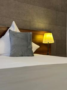 a white bed with a pillow and a lamp at No107 Predeal in Predeal
