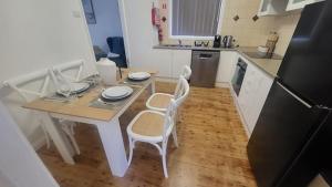 a kitchen with a table and two chairs and a table and a refrigerator at Family Friendly - 5 Mins To Beach in Belmont