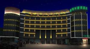 a large building with lights on it at night at GreenTree Inn Suzhou Shengze Hotel in Suzhou
