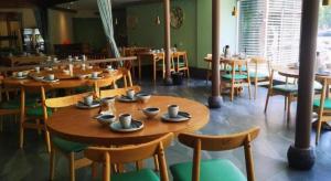 a dining room with wooden tables and chairs at GreenTree Inn Suzhou Shengze Hotel in Suzhou