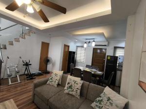 a living room with a couch and a dining room at Villa Maria 1 in Bacolod
