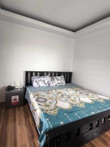 a bedroom with a bed with a blue comforter at Villa Maria 1 in Bacolod
