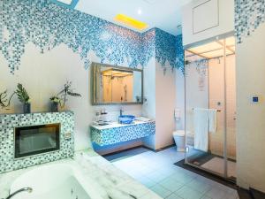 a bathroom with a tub and a toilet and a mirror at Moon Area Motel in Douliu