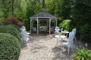 a gazebo with tables and chairs in a garden at Cedars of Williamsburg Bed & Breakfast in Williamsburg