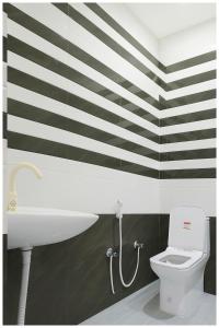 uma casa de banho com uma parede listrada a preto e branco em Ayodhya The Kanha- Shiva Homestay Near Parking and Free Wifi Facility - Fully Air conditioning Comfortable Room - Best Budget Homestay IN Ayodhya em Ayodhya