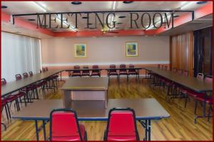 a meeting room with tables and red chairs at Stay Inn - Bartow in Bartow