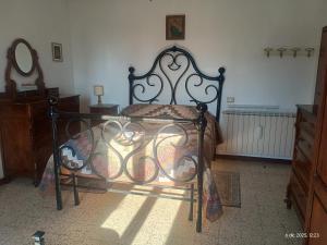 a bedroom with a bed with a wrought iron frame at Casa Branchetti in Quarrata +14 photos