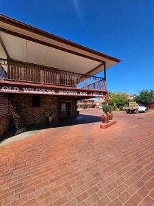 Old Willyama Motor Inn في بروكن هيل: مبنى ذو أرضية من الطوب وشرفة