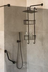 a shower with a shower head and a shower at Rissie's Villa in Gordonʼs Bay