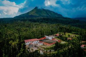an aerial view of a building in front of a mountain at Anvitha Mansions in Attigundi