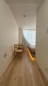 um quarto com uma cama, uma cadeira e uma mesa em Moon Base Tokyo Inn em Tóquio