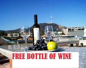 a bottle of wine and two wine glasses on a table at Tbiliseli Inn in Tbilisi City