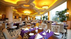 Country Garden Phoenix Hotel Changsha في Xingsha: غرفة طعام مع طاولات وكراسي في مطعم