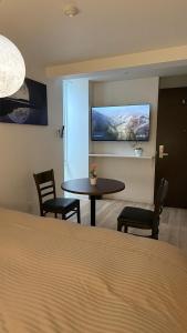 um quarto com uma mesa e uma televisão na parede em Moon Base Tokyo Inn em Tóquio mais 57 fotografias