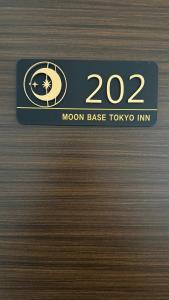 uma porta de metal com uma placa que diz base lunar tokyoin em Moon Base Tokyo Inn em Tóquio mais 57 fotografias