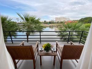 สวนนงนุช เลคไซด์วิลล่า في Ban Nong Chap Tao: بلكونه فيها كرسيين وطاولة مطلة