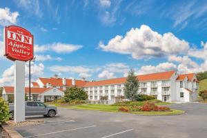 a sign in a parking lot in front of a hotel at The Inn at Apple Valley, an Ascend Collection Hotel in Pigeon Forge