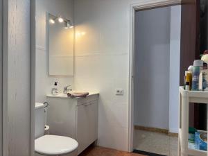 a bathroom with a toilet and a sink and a mirror at Pieds dans l'eau - vue sur mer - Playa de Melenara in Melenara +48 photos