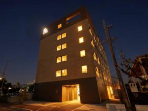 a tall building with many windows at night at EZ HOTEL Kansai Airport Seaside in Izumi-Sano