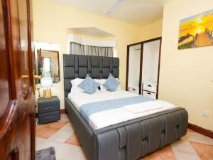 a bedroom with a large bed with blue pillows at Cosy 1 BR with Swimming Pool & Garden & 25 Mins to Airport - C04 in Mombasa +41 photos
