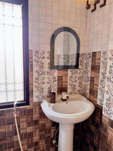 ein Badezimmer mit Waschbecken und Spiegel in der Unterkunft Studio 303 Urban Luxe Micro in Deoghar