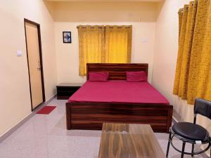 ein Schlafzimmer mit einem Bett mit einer roten Tagesdecke in der Unterkunft Studio 303 Urban Luxe Micro in Deoghar