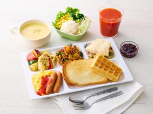a plate of breakfast food with toast and waffles and a drink at Comfort Hotel Narita in Narita