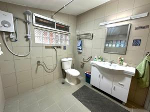 a bathroom with a shower and a toilet and a sink at Kampung B&B Homestay in Kampong Pepedonkiang +34 photos