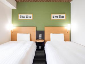 Giường trong phòng chung tại Comfort Hotel Kurosaki +21 ảnh