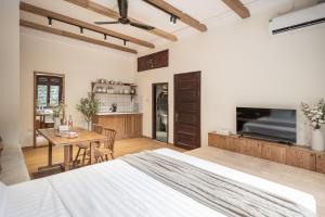 a bedroom with a bed and a table and a tv at Urban Horizon Boutique Suites in Hanoi
