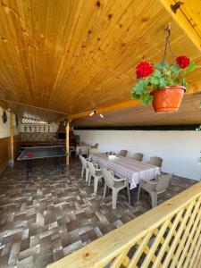 a dining room with a ping pong table and chairs at Pensiunea CAV in Novaci