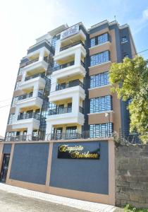 a tall building with a sign in front of it at Araka Homes in Nakuru