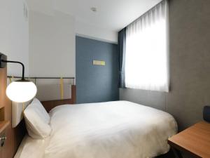 a bedroom with a white bed and a window at Comfort Hotel Yokkaichi in Yokkaichi +48 photos