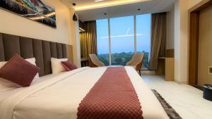 een slaapkamer met een groot bed met een groot raam bij Travinities Hotel Shree Ji Palace in Ujjain