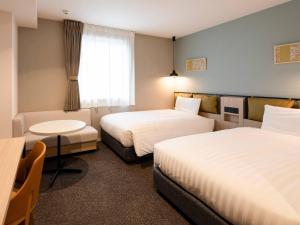 a hotel room with two beds and a table at Comfort Hotel Mito in Mito +72 photos