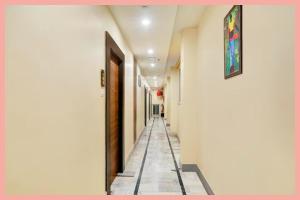 Un pasillo con paredes blancas y suelo de baldosas. en Rajshekhar PVS - Grand Premium Near Vishwanath Temple -Luxury And Spacious Rooms -Wifi #Parking #Lift - BEST HOTEL, en Varanasi