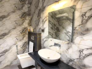 een badkamer met een wastafel en een spiegel bij Travinities Hotel Shree Ji Palace in Ujjain