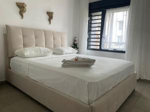 a white bed with towels on it in a bedroom at T3 Rosa - 59m2 avec piscine commune - Saint-Leu in Saint-Leu +10 photos
