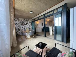 a living room with a couch and a table at T3 Rosa - 59m2 avec piscine commune - Saint-Leu in Saint-Leu