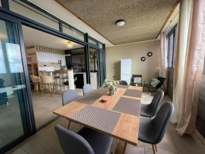 a dining room with a table and chairs at T3 Rosa - 59m2 avec piscine commune - Saint-Leu in Saint-Leu