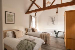 a bedroom with two beds and a desk in it at Stunning 5-bed Barn Conversion in Newark-on-Trent by Renzo, Beautiful Surroundings, Sleeps 10! in Besthorpe +33 photos