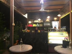 una mujer sentada en el mostrador de un restaurante en Kampong Pinang Sebatang Melaka, en Pengkalan Balak