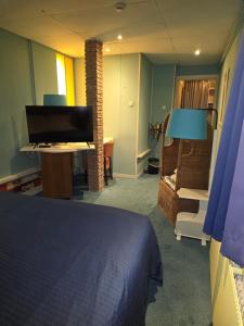 a bedroom with a bed and a desk with a computer at Hotel Hoogland Zandvoort aan Zee in Zandvoort