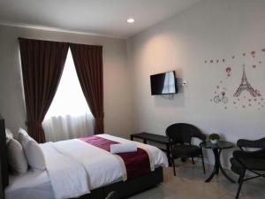 a bedroom with a bed and a table and a tv at PPT Muar Hotel in Kampung Tanjung Agas +57 photos