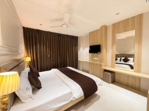Un dormitorio con una cama grande y un espejo. en Hotel RK Residency, en Ujjain