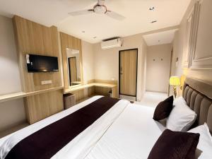 una habitación de hotel con cama y televisor de pantalla plana en Hotel RK Residency, en Ujjain