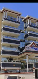 ein hohes Gebäude mit einem Schild davor in der Unterkunft Downtown Retreat Homes in Kisii