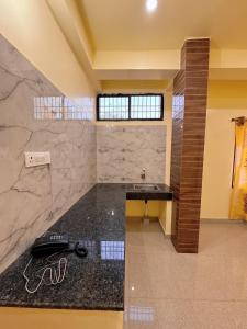 ein Bad mit einer schwarzen Theke und einem Waschbecken in der Unterkunft Studio 304 Modern Serenity in Deoghar